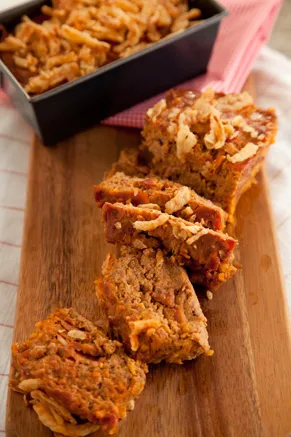 Paula Deen Bacon Cheeseburger Meatloaf topped with French fried onions in a loaf pan