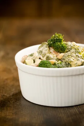 Paula Deen Cheesy Broccoli Bake in a casserole dish topped with melted cheddar cheese