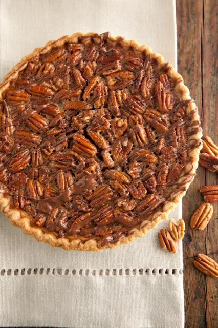 A slice of Paula Deen chocolate pecan pie showing the fudgy chocolate filling and toasted pecan halves