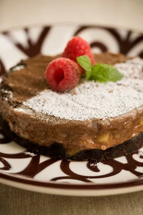 Double chocolate ooey gooey butter cake sliced on a plate showing the fudgy chocolate center