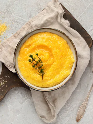Creamy goat cheese grits served in a bowl, cooked with butter and milk