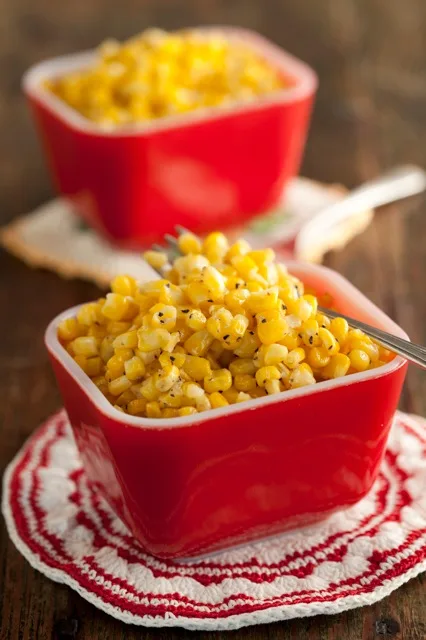 A skillet of Paula Deen Mama's fried cream corn made with fresh corn, bacon, and butter