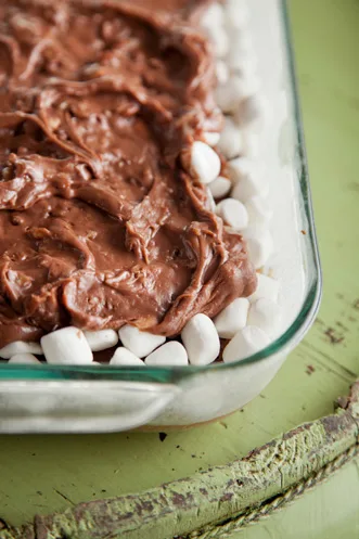 Paula Deen Mississippi Mud Cake with melted marshmallows and chocolate pecan icing on a baking pan