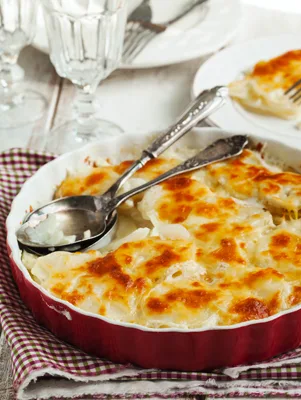 Paula Deen Potatoes au Gratin baked golden brown with Gruyere and Parmesan in a gratin dish