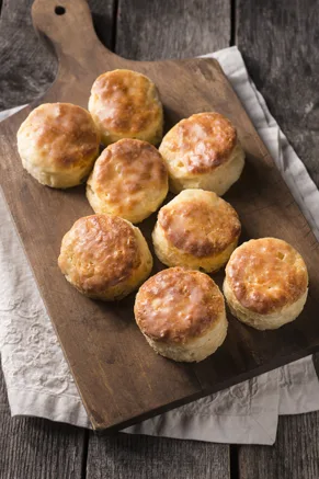 Paula Deen angel biscuits golden brown on a wooden cutting board
