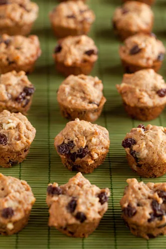 Paula Deen apple raisin muffins in miniature size with raisins and walnuts on a green bamboo mat