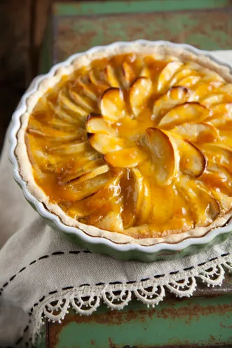 Paula Deen apple tart with overlapping apple slices and a golden apricot glaze in a round baking dish