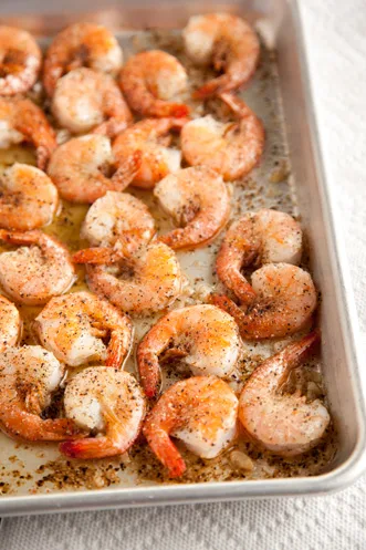 Paula Deen black pepper shrimp baked in the shell on a sheet pan with garlic butter and cracked black pepper