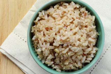 Paula Deen brown rice served in a teal bowl on a cream linen napkin