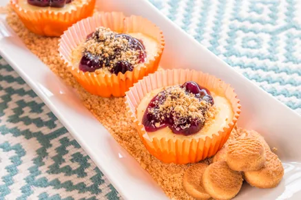 Paula Deen cherry cream cheese tarts in orange paper liners topped with cherry pie filling and graham cracker crumbs with vanilla wafers on the side