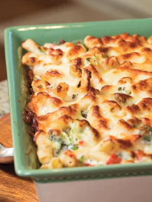 Paula Deen chicken alfredo pasta bake with golden melted mozzarella in a green baking dish