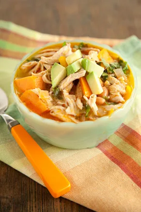 Paula Deen chicken chili stew in a light green bowl with shredded chicken, sweet potato, pinto beans and diced avocado