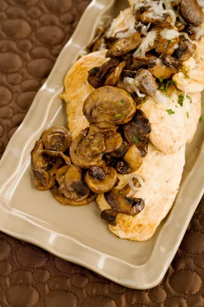 Paula Deen Chicken Georgia with sauteed mushrooms and melted mozzarella on a beige platter