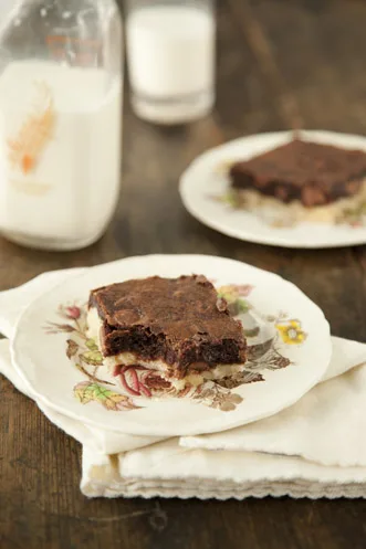 Paula Deen Chocolate Heaven Brownie Pie square on a floral plate with a bottle of milk in the background