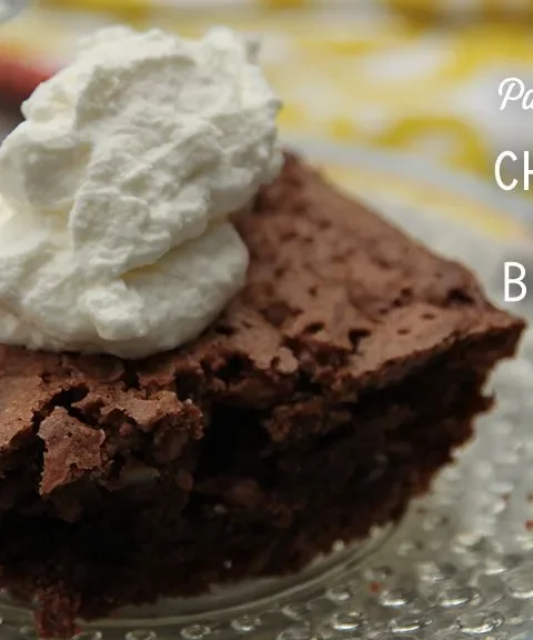 Paula Deen chocolate mound brownie square topped with a swirl of whipped cream on a glass plate