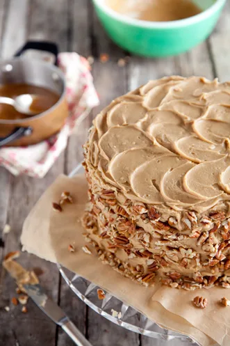 Paula Deen chocolate pecan layer cake with swirled caramel frosting and chopped pecans pressed around the sides