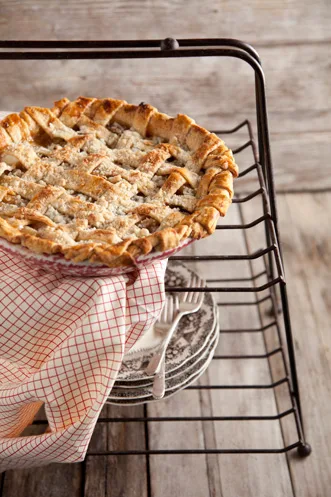 Paula Deen crunch top apple pie with a golden lattice crust and crumbly topping on a wire rack beside a red checkered towel
