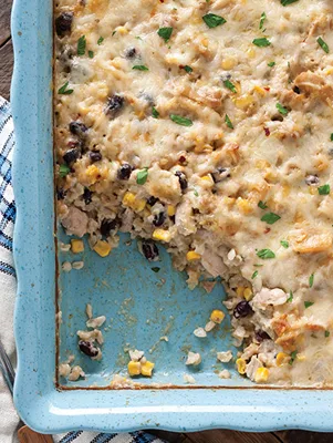 Paula Deen easy cheesy chicken casserole in a blue baking dish with melted cheese, black beans, corn and chicken