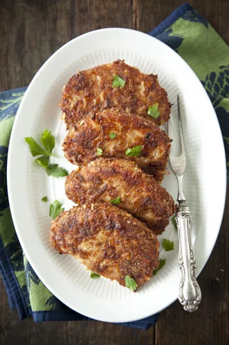 Paula Deen French Onion Pork Chops, golden breadcrumb-crusted boneless chops garnished with fresh parsley on a white oval platter