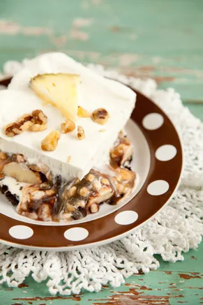 Paula Deen frozen banana split square with whipped topping, toffee bits and layers of fudge and butterscotch on a brown polka dot plate