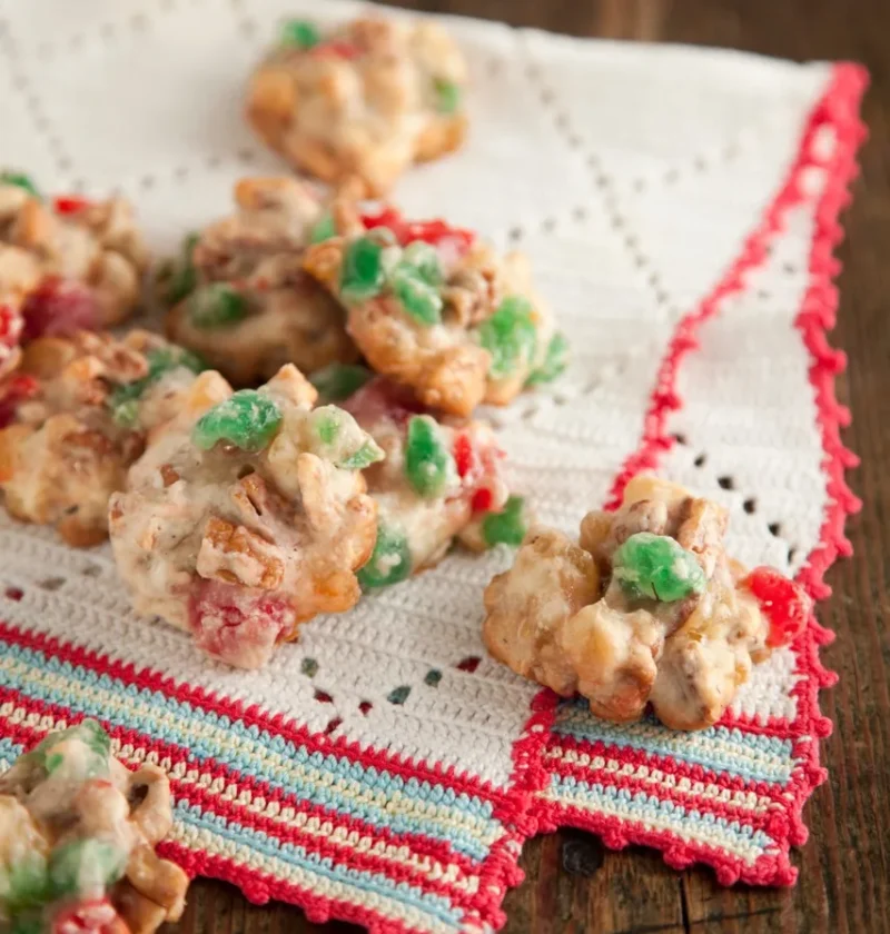 Paula Deen fruitcake drop cookies studded with red and green candied cherries and pecans on a white crocheted towel