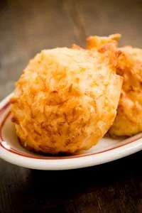 Paula Deen garlic cheese biscuits, golden brown with crisp edges, served on a small white plate with a red rim