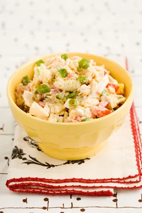 Paula Deen Georgia Cracker Salad in a yellow bowl with chopped tomato, egg and green onions