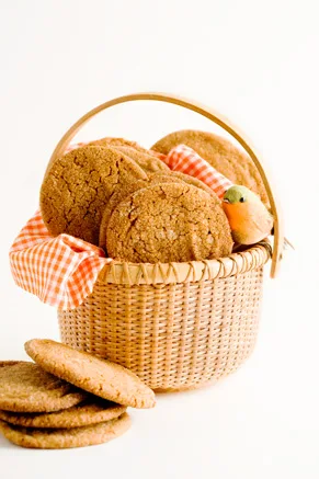 Paula Deen ginger cookies with crackly sugar-coated tops piled in a woven basket lined with an orange gingham napkin
