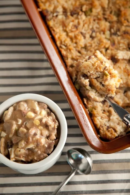 Paula Deen good old country stuffing baked in a casserole dish with a bowl of mushroom giblet gravy