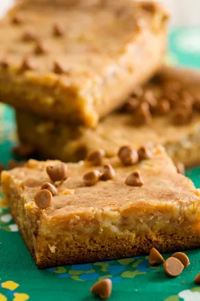 Paula Deen gooey toffee butter cake squares topped with toffee bits on a green patterned cloth