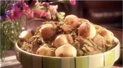 Paula Deen green beans with new potatoes and salt pork served in a striped bowl