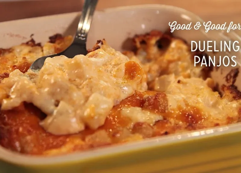 Paula Deen hash brown potato casserole with a golden browned cheddar top in a yellow baking dish with a spoon