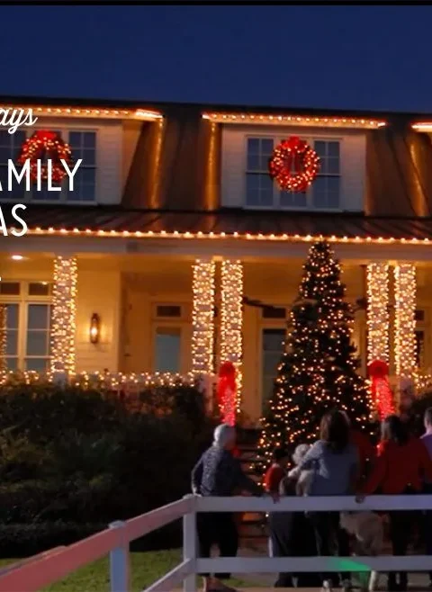 Paula Deen holiday sandies shown in a festive Christmas scene with a decorated house and lit tree
