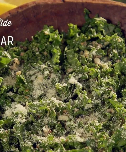 Paula Deen kale Caesar salad with thin lacinato kale ribbons and grated Parmesan in a wooden bowl
