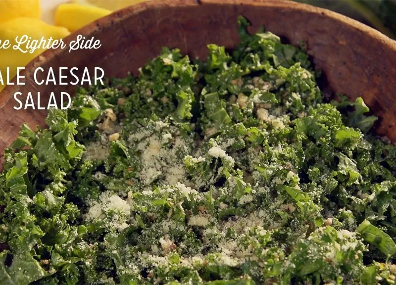 Paula Deen kale Caesar salad with thin lacinato kale ribbons and grated Parmesan in a wooden bowl