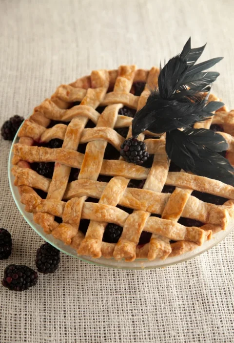 Paula Deen lattice-top blackberry blackbird pie with a golden woven crust and a black feather crow on top