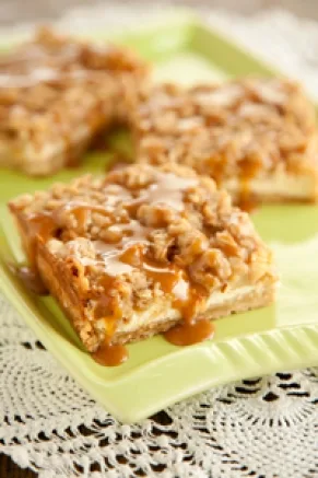Paula Deen lighter caramel apple cheesecake bars with oat crumble topping and caramel drizzle on a green square plate