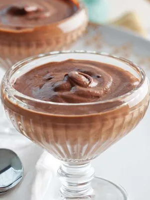 Paula Deen old-fashioned chocolate pudding swirled in a glass footed dessert dish with a second dish and a spoon beside it