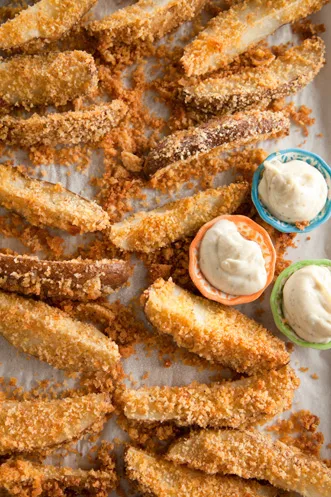 Paula Deen oven-fried potato wedges with a golden cornbread crust served with three small bowls of creamy dip