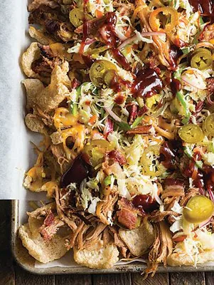 Paula Deen pulled pork nachos on a sheet pan with pork rinds, melted cheese, pickled jalapeños, coleslaw and barbecue sauce