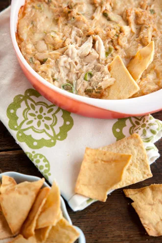 Paula Deen Savannah hot crab dip baked in a red dish with green onions, served with pita chips