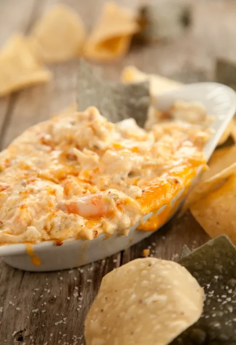 Paula Deen Shore Is Good seafood dip, a creamy baked crab and shrimp dip in a white dish surrounded by tortilla chips