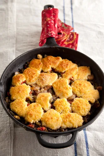 Paula Deen shrimp gumbo casserole with golden corn muffin topping baked in a cast iron skillet