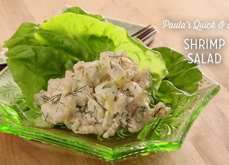 Paula Deen shrimp salad with fresh dill scooped into a Bibb lettuce cup on a green glass dish