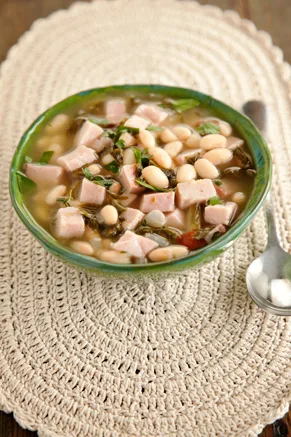 Paula Deen simple Southern ham and bean soup in a green bowl with diced ham, white beans and collard greens