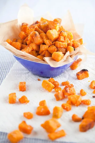 Paula Deen sweet potato home fries, crisp golden cubes piled in a blue bowl lined with parchment on a white towel