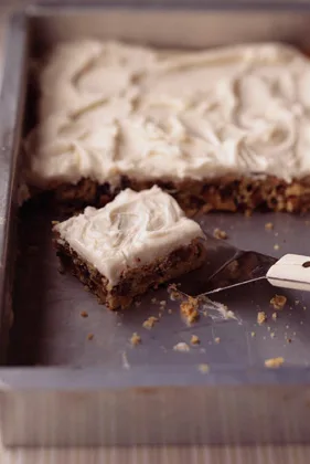 Paula Deen Tennessee whiskey fruit and nut bars with thick whiskey frosting in a 9x13 pan with one square lifted out