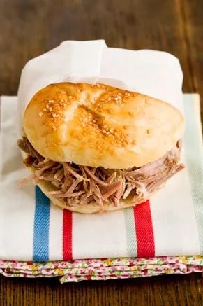 Paula Deen The Lady and Son's smoked Boston butt roast piled into a sesame-topped bun on a striped dish towel
