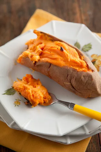 Paula Deen twice baked sweet potatoes with creamy golden filling on a white plate with a fork